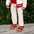 18-inch doll wearing white tracksuit with red strappy sandals with a heel strap in Yoho National Park, British Columbia, Canada.