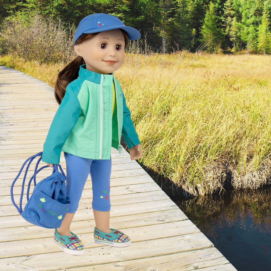 18-inch doll wearing colourful outdoor outfit with many pieces includes drawstring bag.