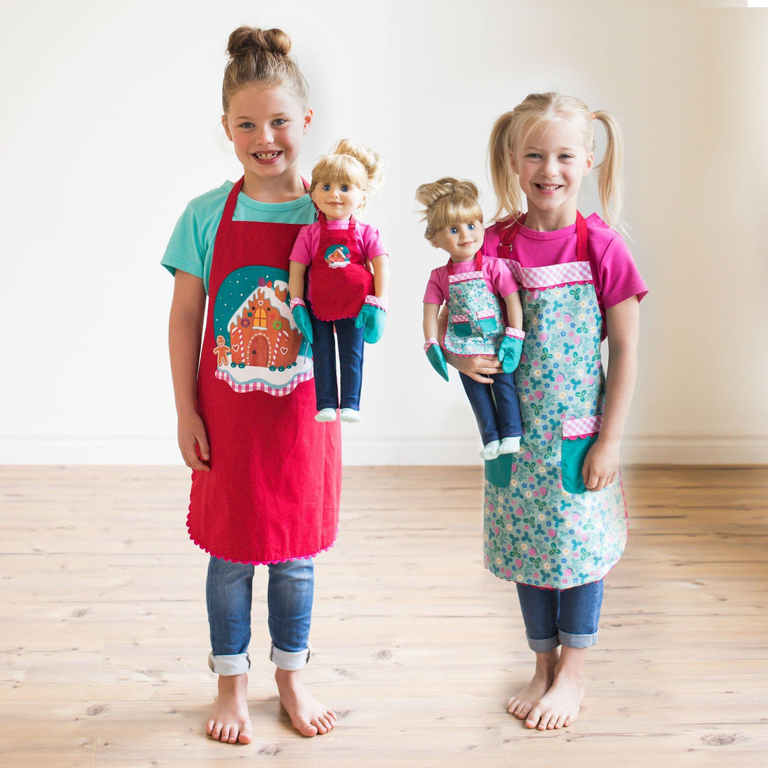 Reversible apron set with gingerbread holiday scene and floral pattern on the other side, with matching girl and doll plus doll-sized oven mitts