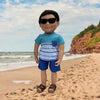 18-inch boy doll wearing summer clothes and sunglasses on a beach in Eastern Canada.