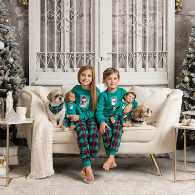Boy and girl wearing pajamas that match their dolls' pjs, with matching bandanas for their dogs