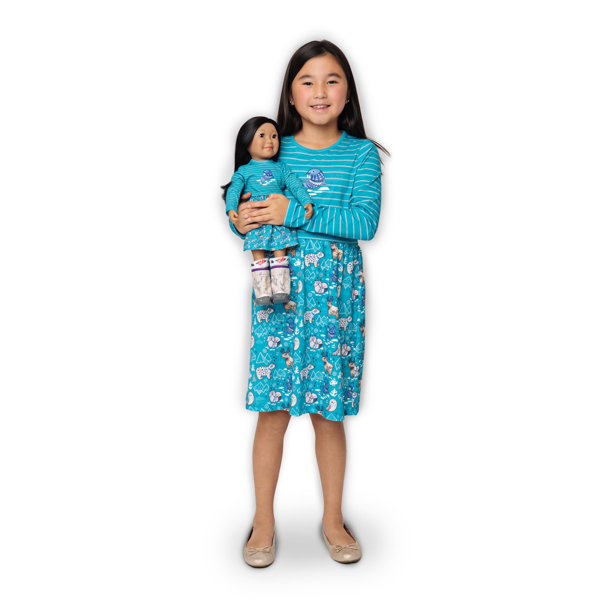 Girl and doll wearing matching dresses with an Arctic Animals theme.  Dress alike with your 18" doll