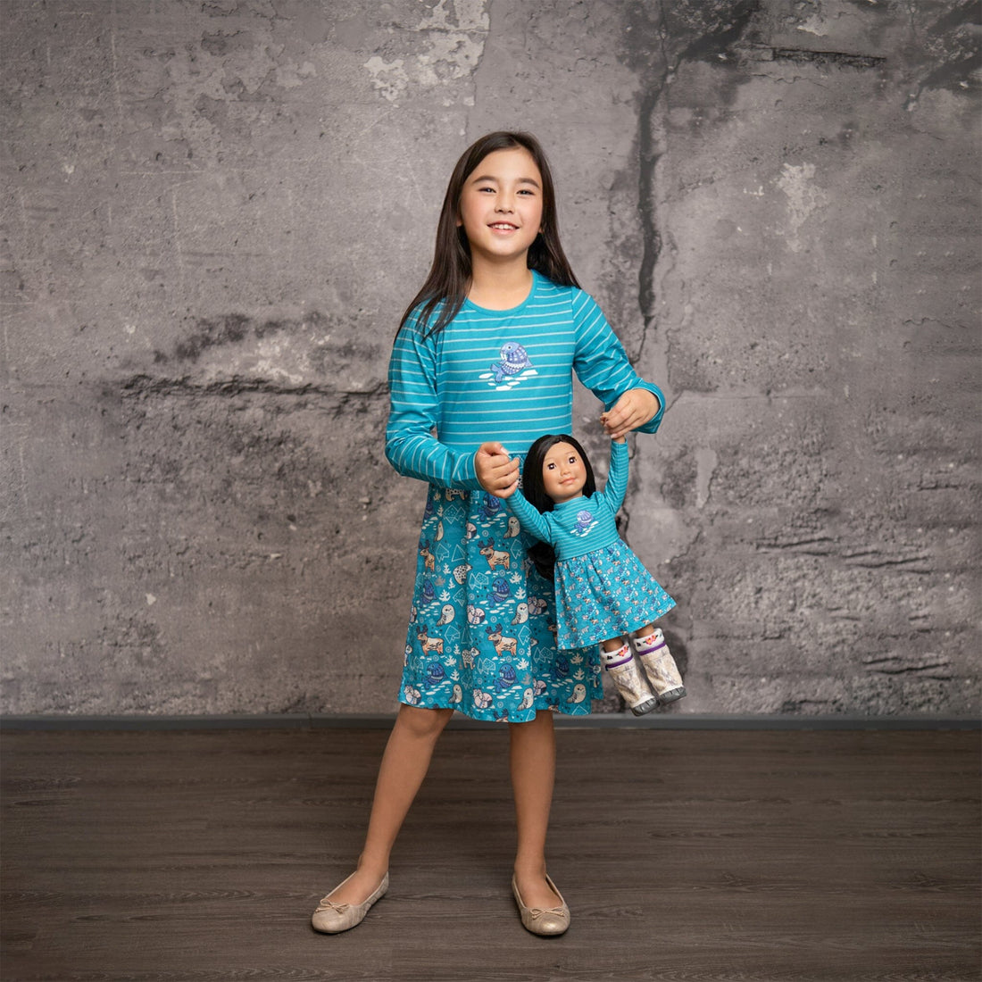 Girl and doll wearing matching dresses with an Arctic Animals theme.  Dress alike with your 18" doll