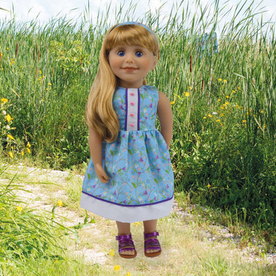 18 inch blonde Maplelea doll wearing crocus patterned dress with headband and purple sandals.