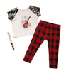 Rockin' Couture black and red plaid pants, white rock n' roll graphic t-shirt with sequin sleeves, and button wrist band fits all 18 inch dolls.