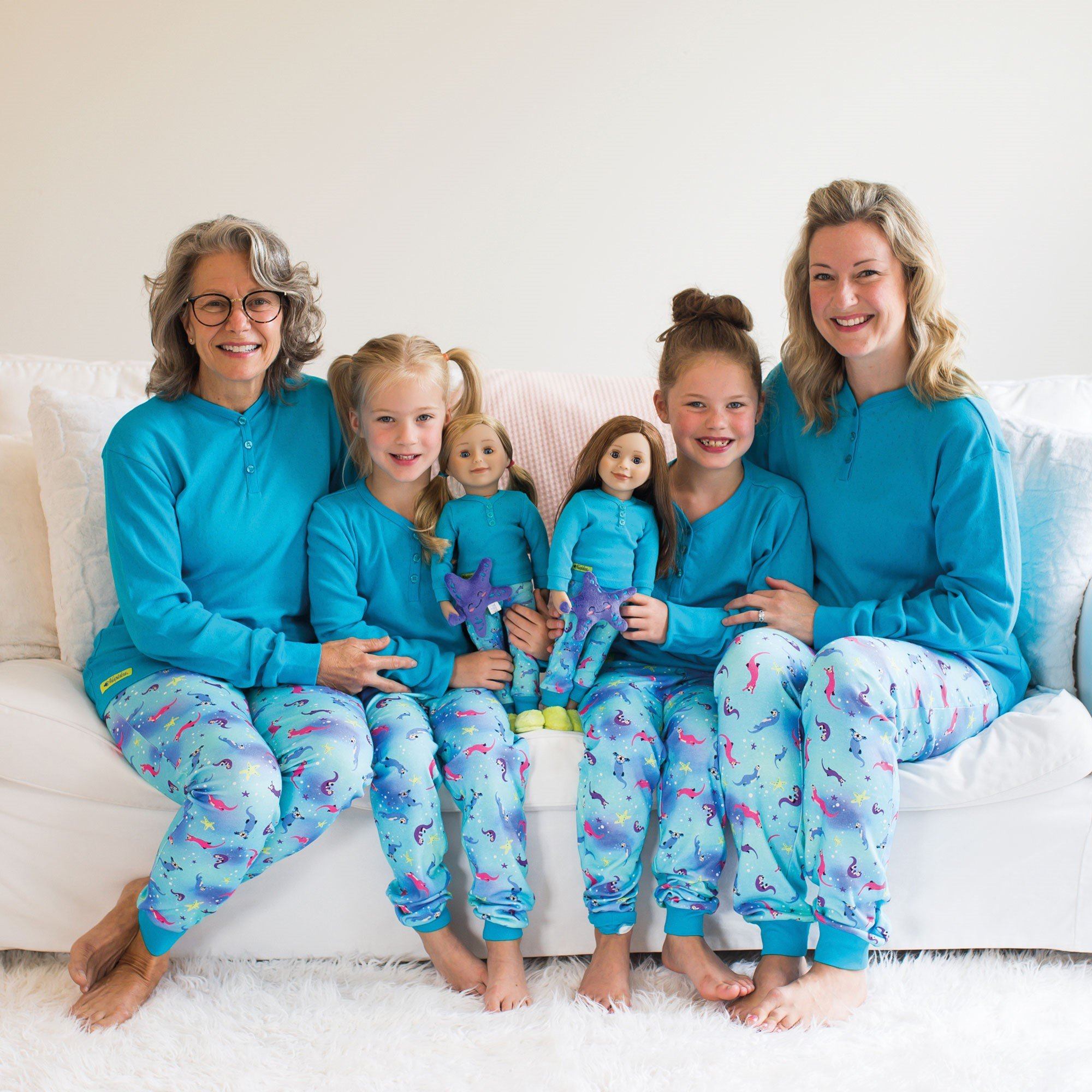 mom, grandma, and girls with their dolls all wearing matching PJs