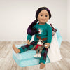 Canadian doll wearing pjs sitting on a lounge chair that converts to a doll bed.